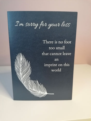 Baby loss condolence card, navy background, white text Im sorry for your loss, There is no foot too small that cannot leave an imprint on this world, single white feather design